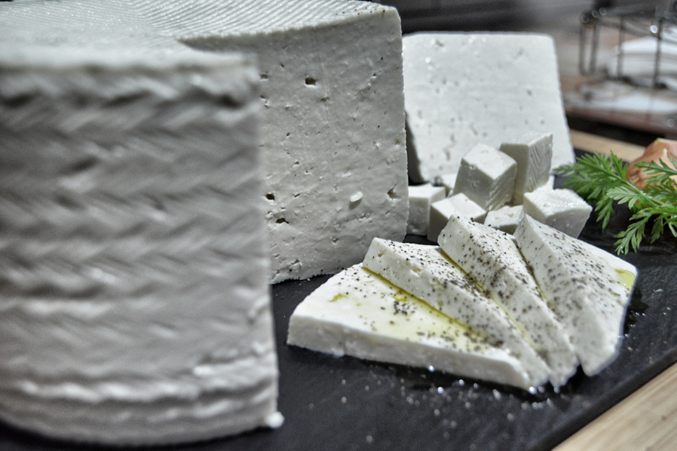 Piezas de queso fresco con corteza trenzada y láminas aliñadas